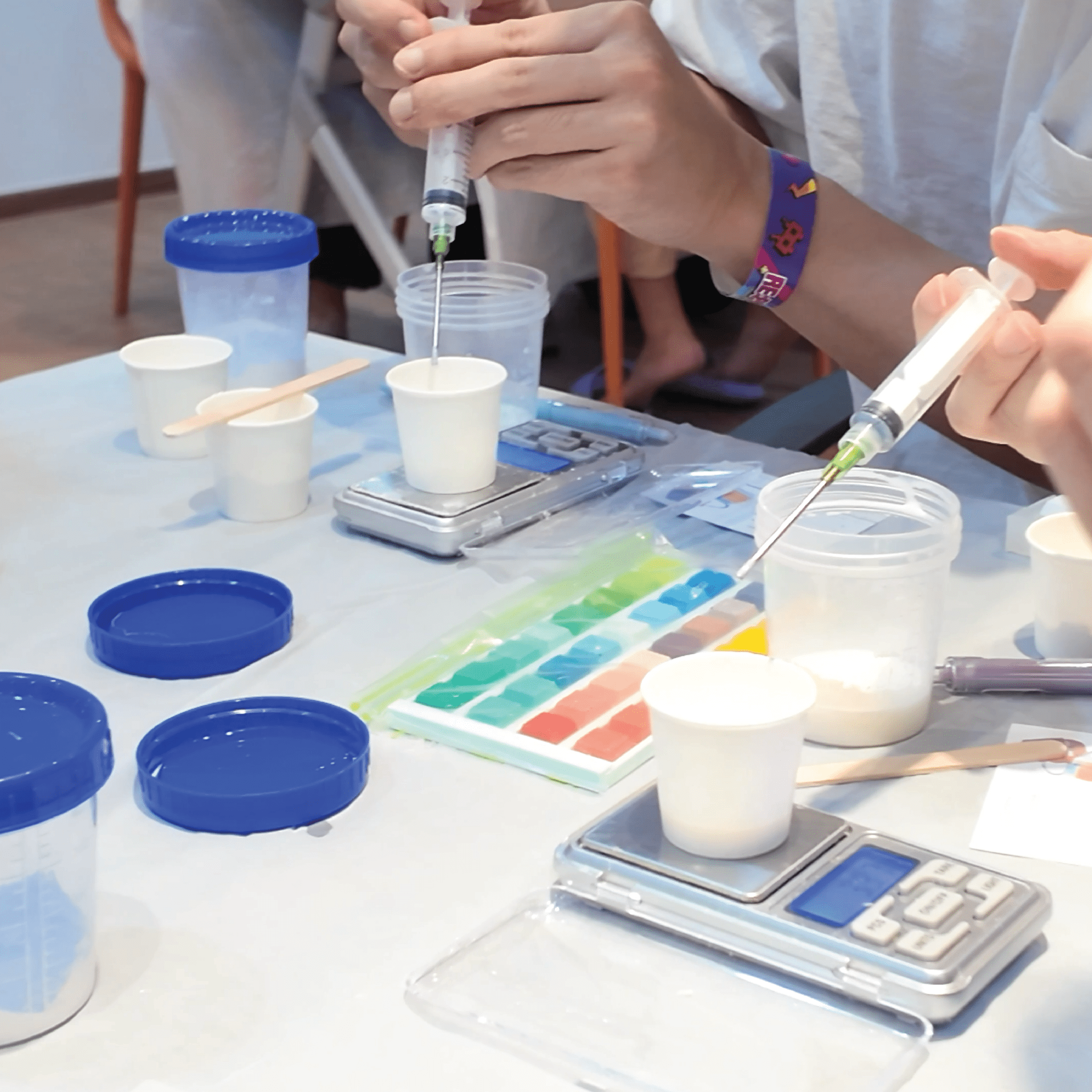 Participant mixing Jesmonite colours using syringes and colour palette at Artzei Studio keycap workshop