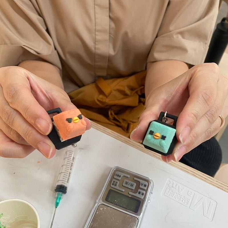 Participant holding two finished bird character keycaps made at Artzei Studio keycap workshop Singapore