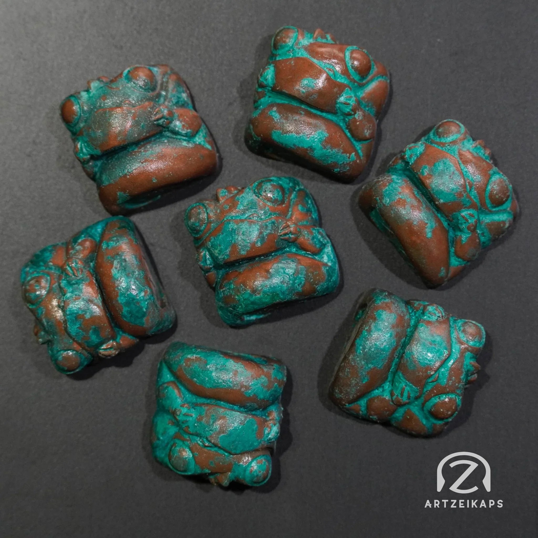 Chomper artisan keycaps in Copper Patina finish laid out on dark background, top-down view