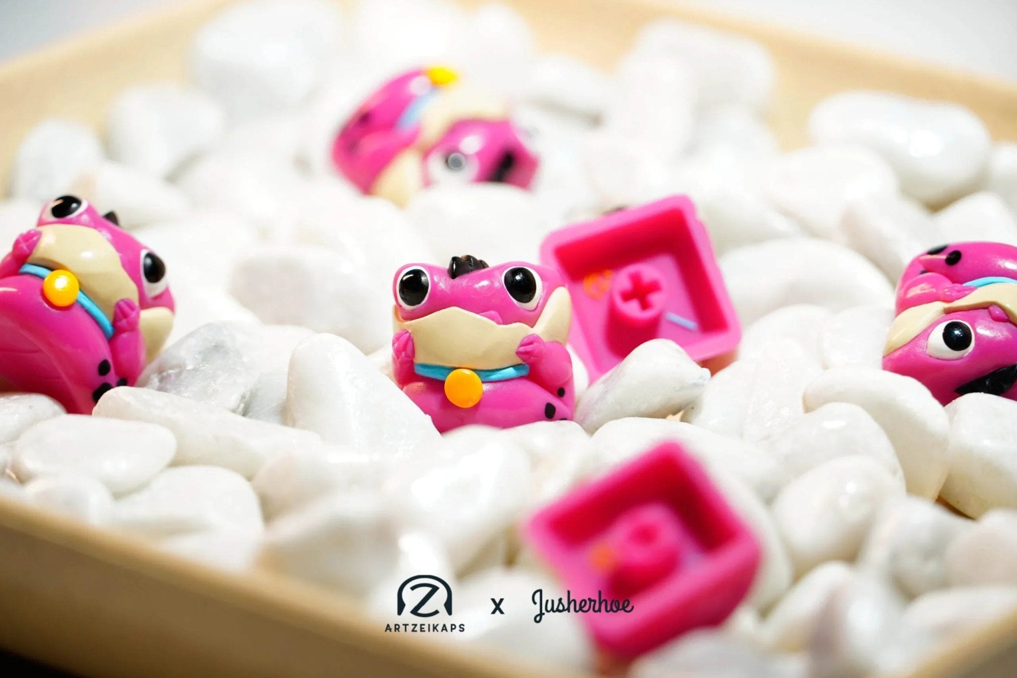 Chomper Flintstones artisan keycaps in pink and teal with rocks, angled view in wooden bowl