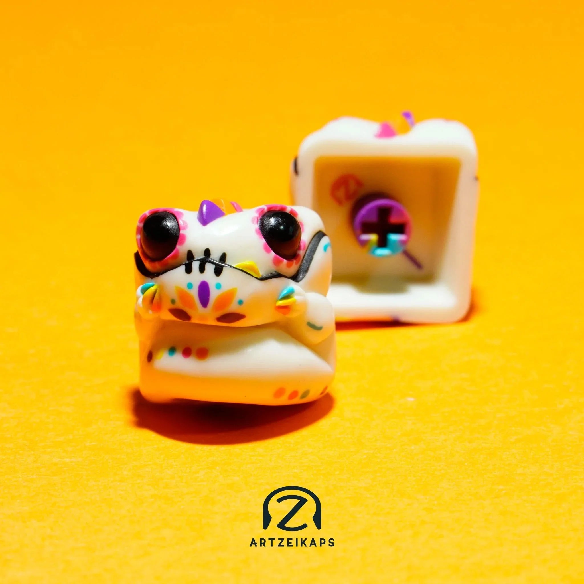 Chomper GMK Mictlan artisan keycap front and back view on yellow background with marigold flowers