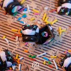 Chomper Gateaux artisan keycap close-up surrounded by colourful sprinkles on wooden surface