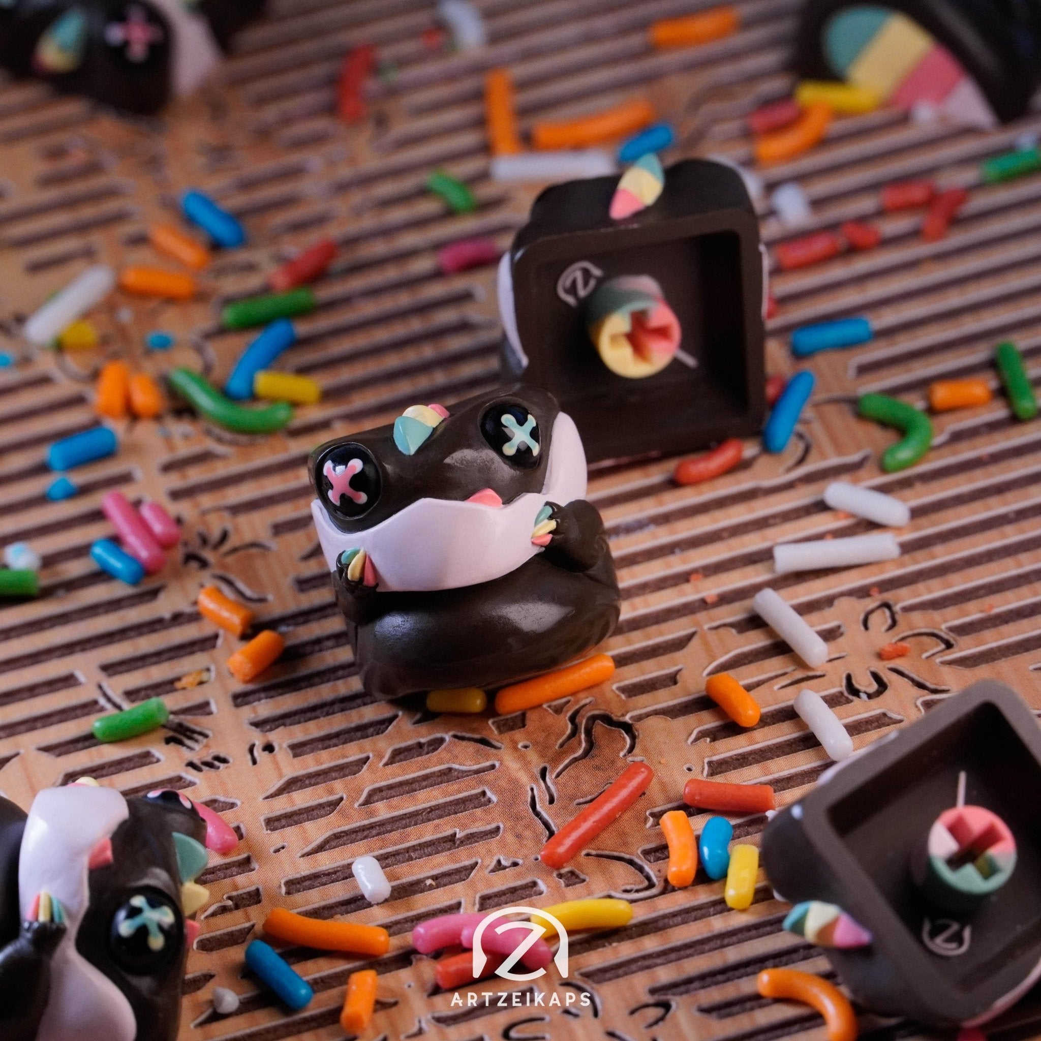 Chomper Gateaux artisan keycap in chocolate brown with rainbow sprinkles, front and back view on wooden surface