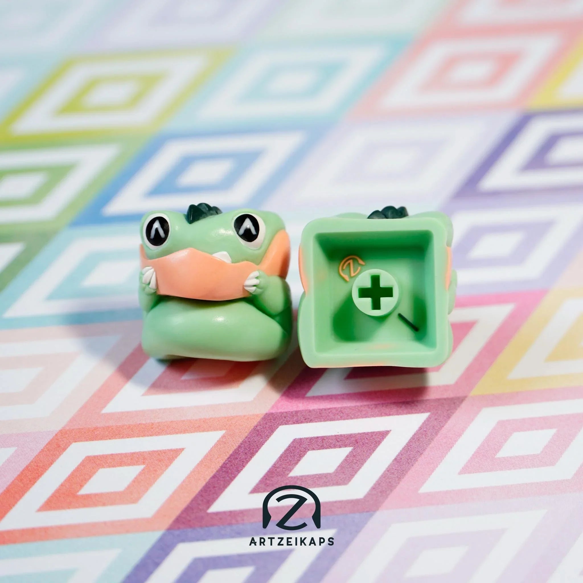 Chomper Minty Peach artisan keycap in mint green with peach nose, front and back view on colourful geometric background