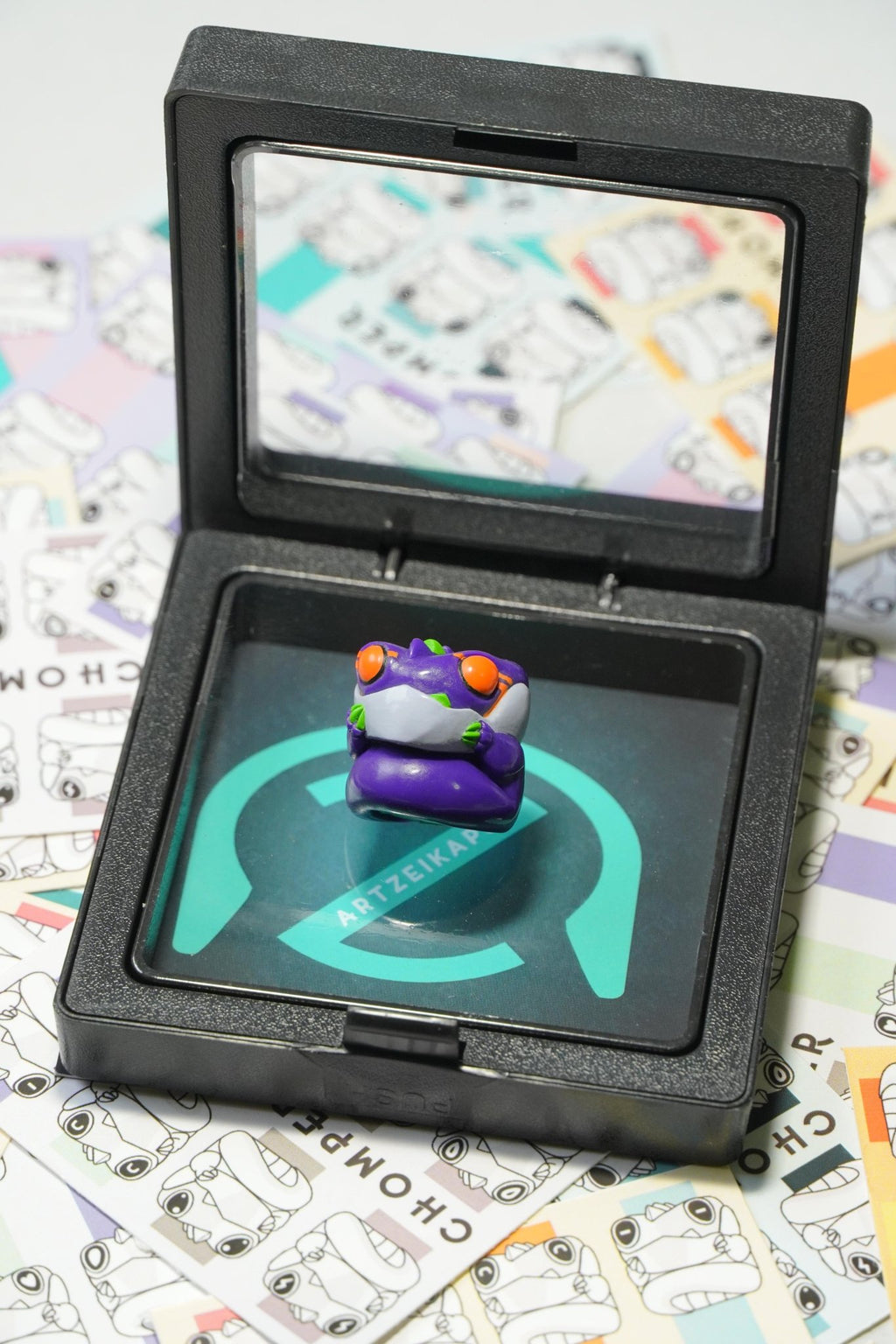 Display of Chomper artisan keycap GMK M-01 colourway in plastic jewelry packaging