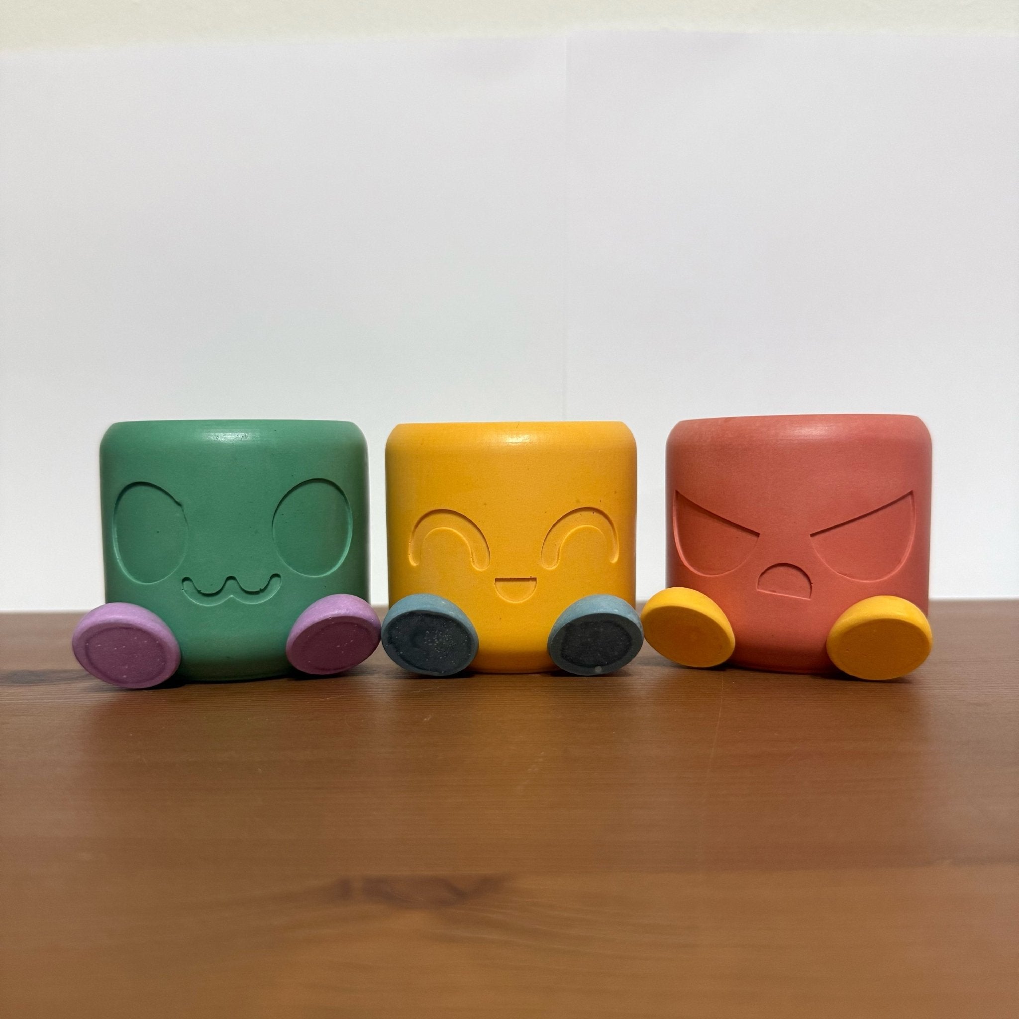 Chonky Pot Mood Edition in dark green, yellow and red with various mood expressions