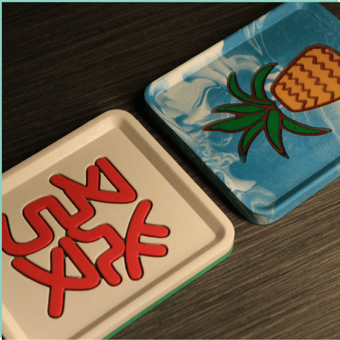 Jesmonite pineapple tray and Fa mahjong tile tray by Artzei Studio displayed together on a desk