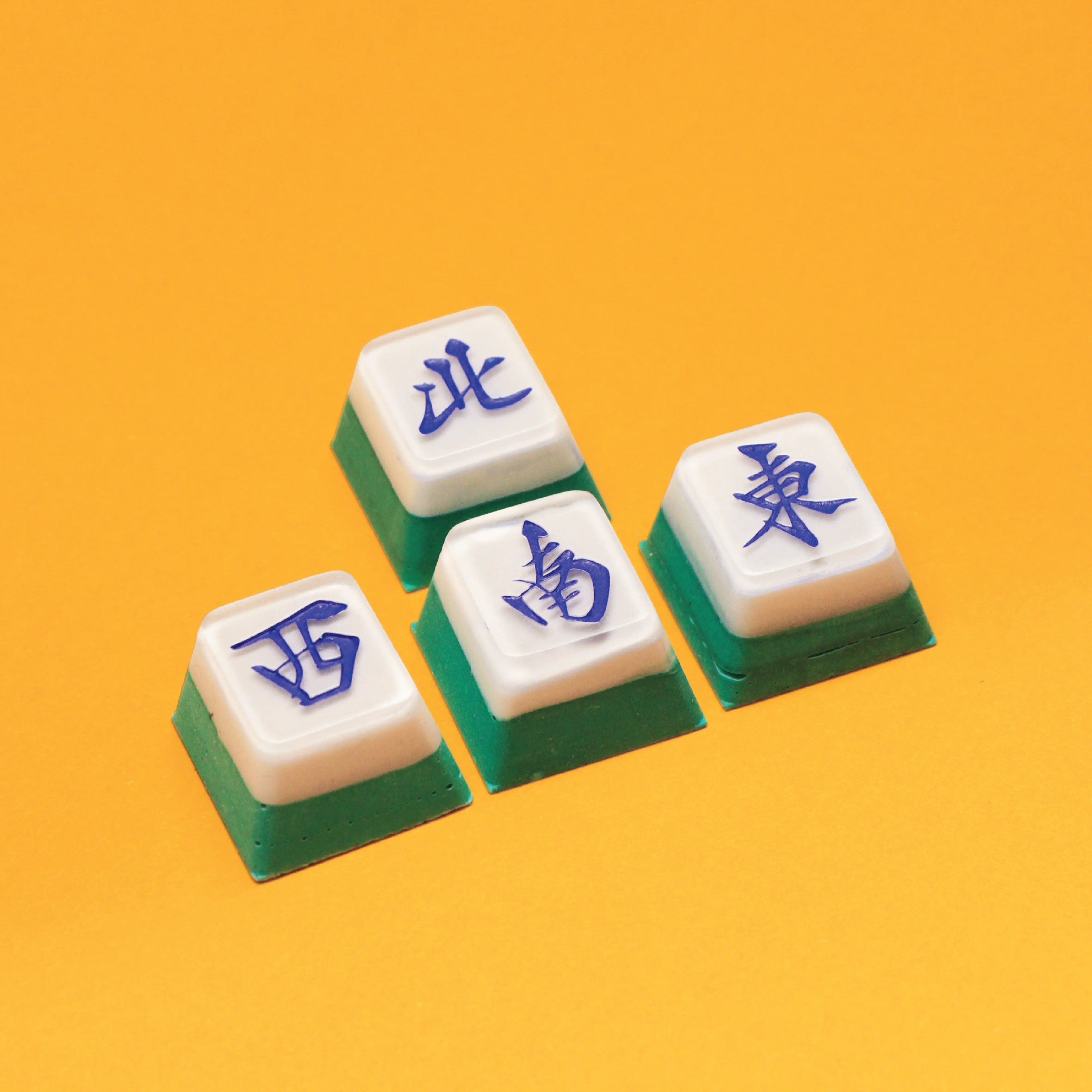 Four Mahjong tiles with blue characters on a yellow background - Mahjong Keycap Workshop Singapore - Corporate Workshops