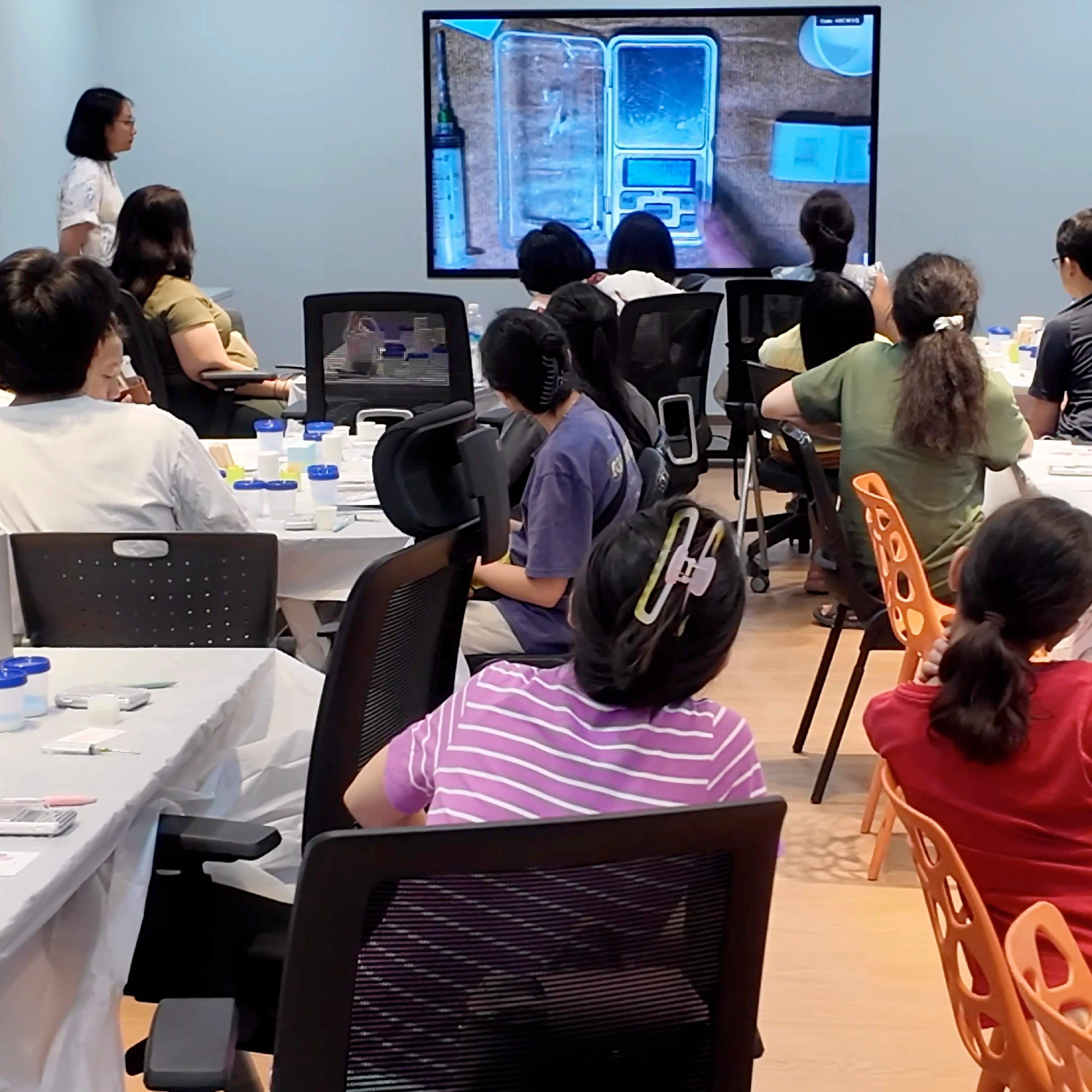 Participants watching a live demonstration during a hands-on craft workshop session.