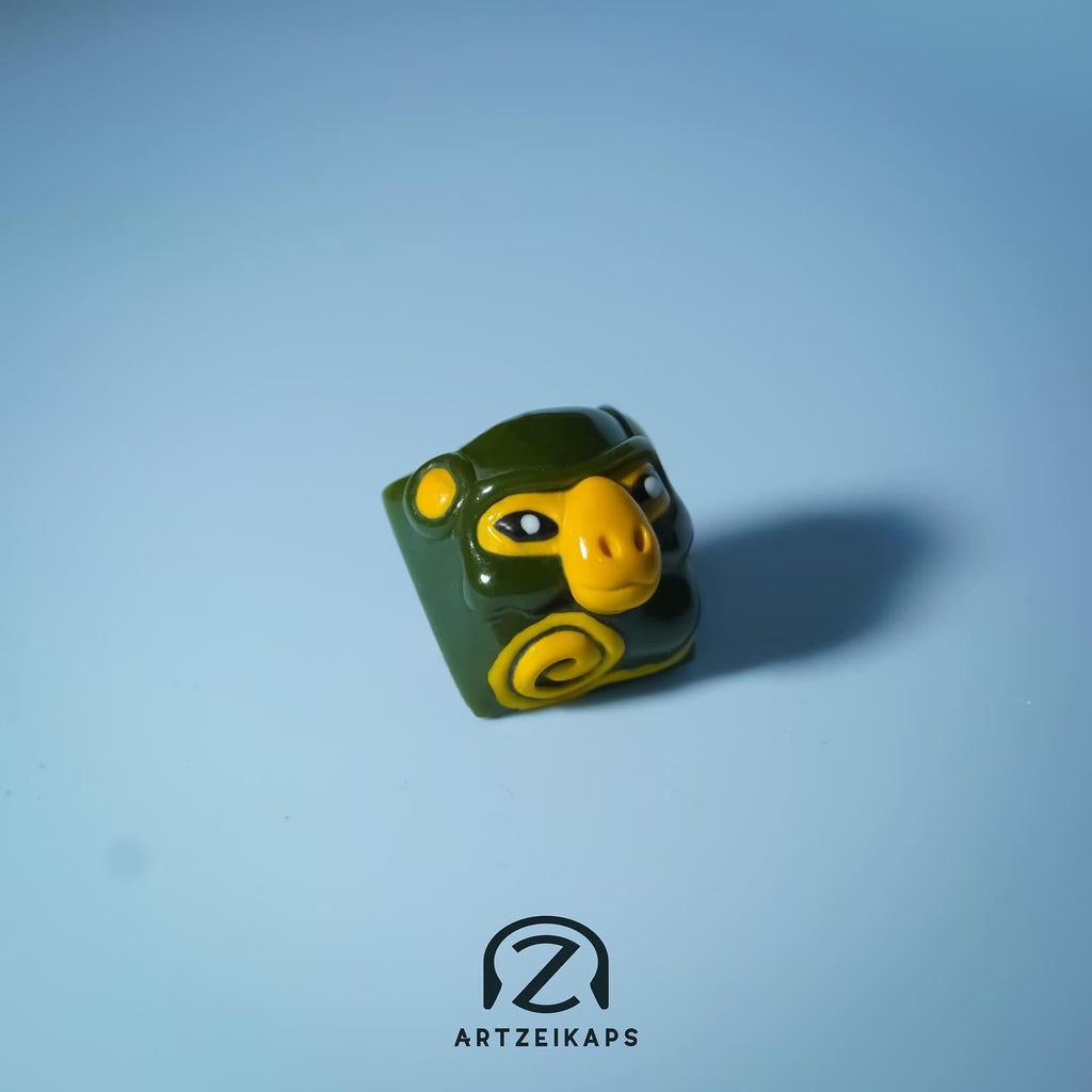 Smunkey Fall '21 artisan keycap in olive green, solo front view on light blue background