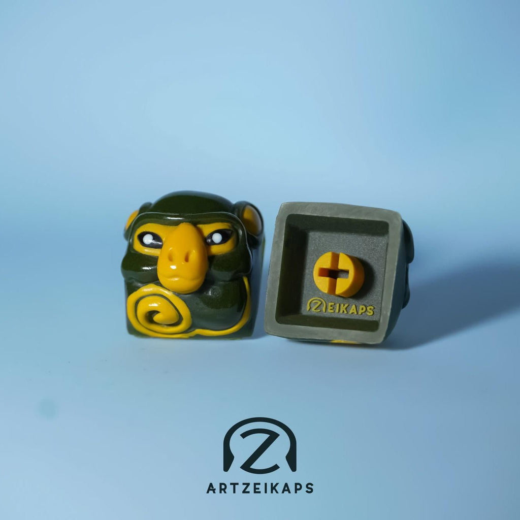 Smunkey Fall '21 artisan keycap in olive green, front and back view on light blue background