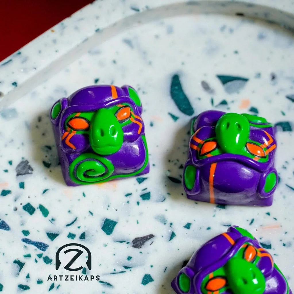 Smunkey GMK M-01 artisan keycap trio scattered on white terrazzo surface, top-down view