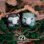 Smunkey GMK November Fog artisan keycap pair in dark brown and sage green, front view on mossy woodland setting