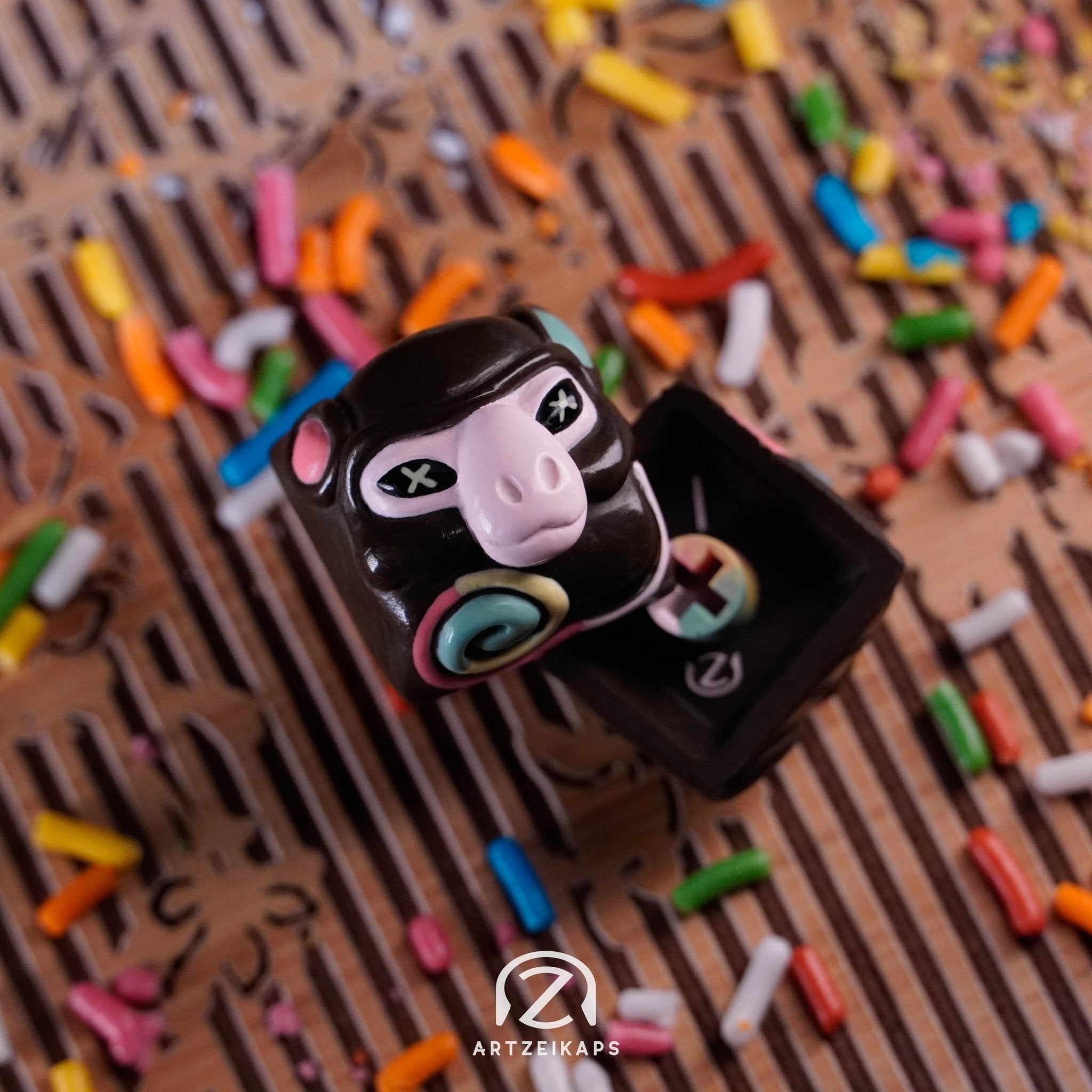 Smunkey Gateaux artisan keycap front and back view with colourful sprinkles on wooden surface