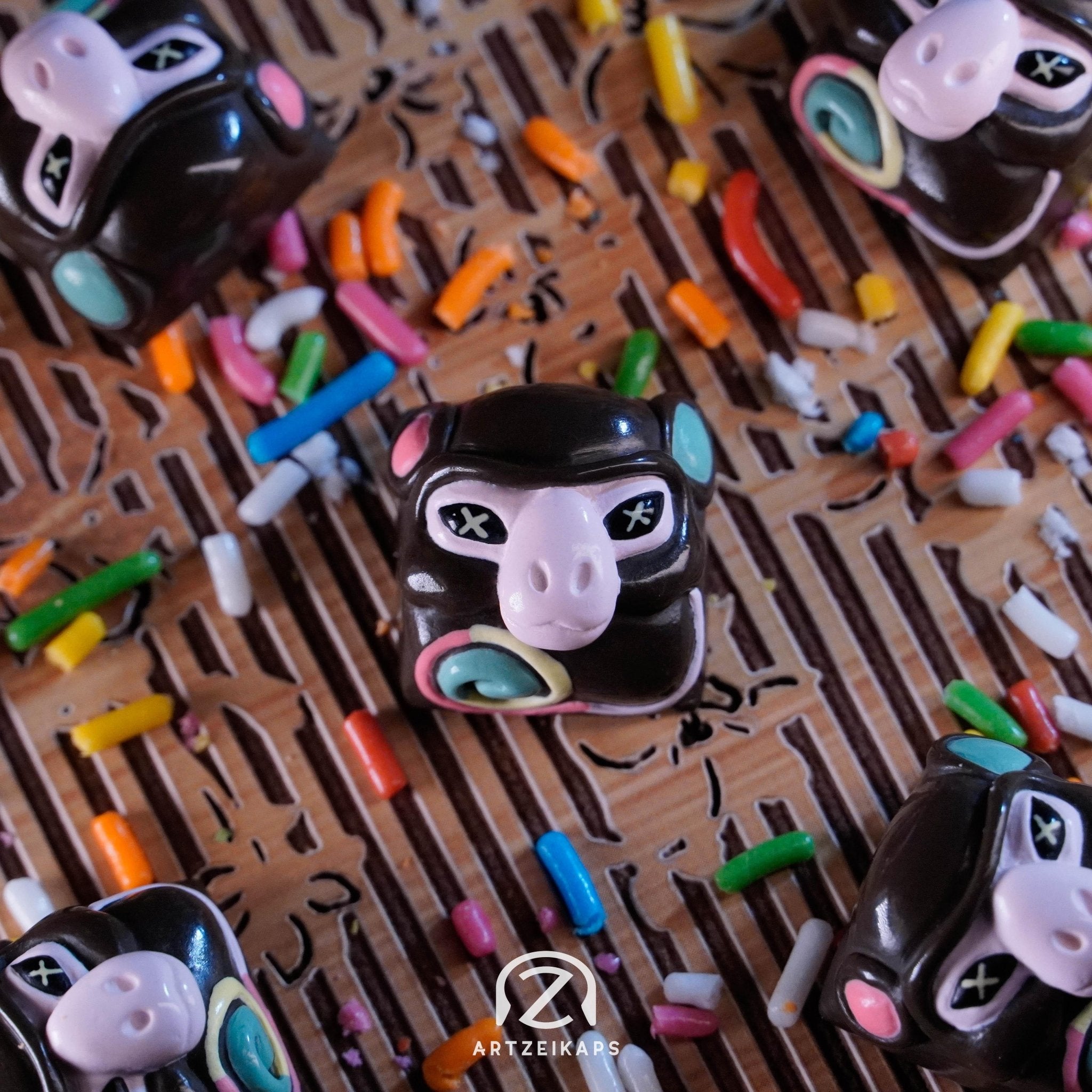 Smunkey Gateaux artisan keycap in chocolate brown with pink nose and rainbow details, top-down view with colourful sprinkles