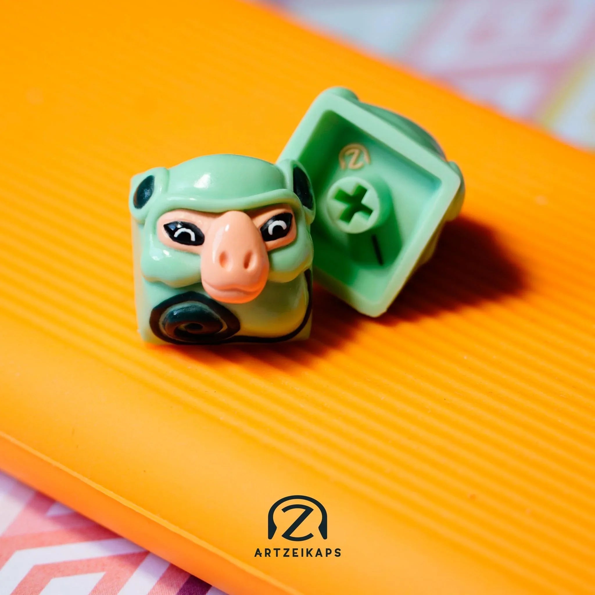 Smunkey Minty Peach artisan keycap front and back view on orange background