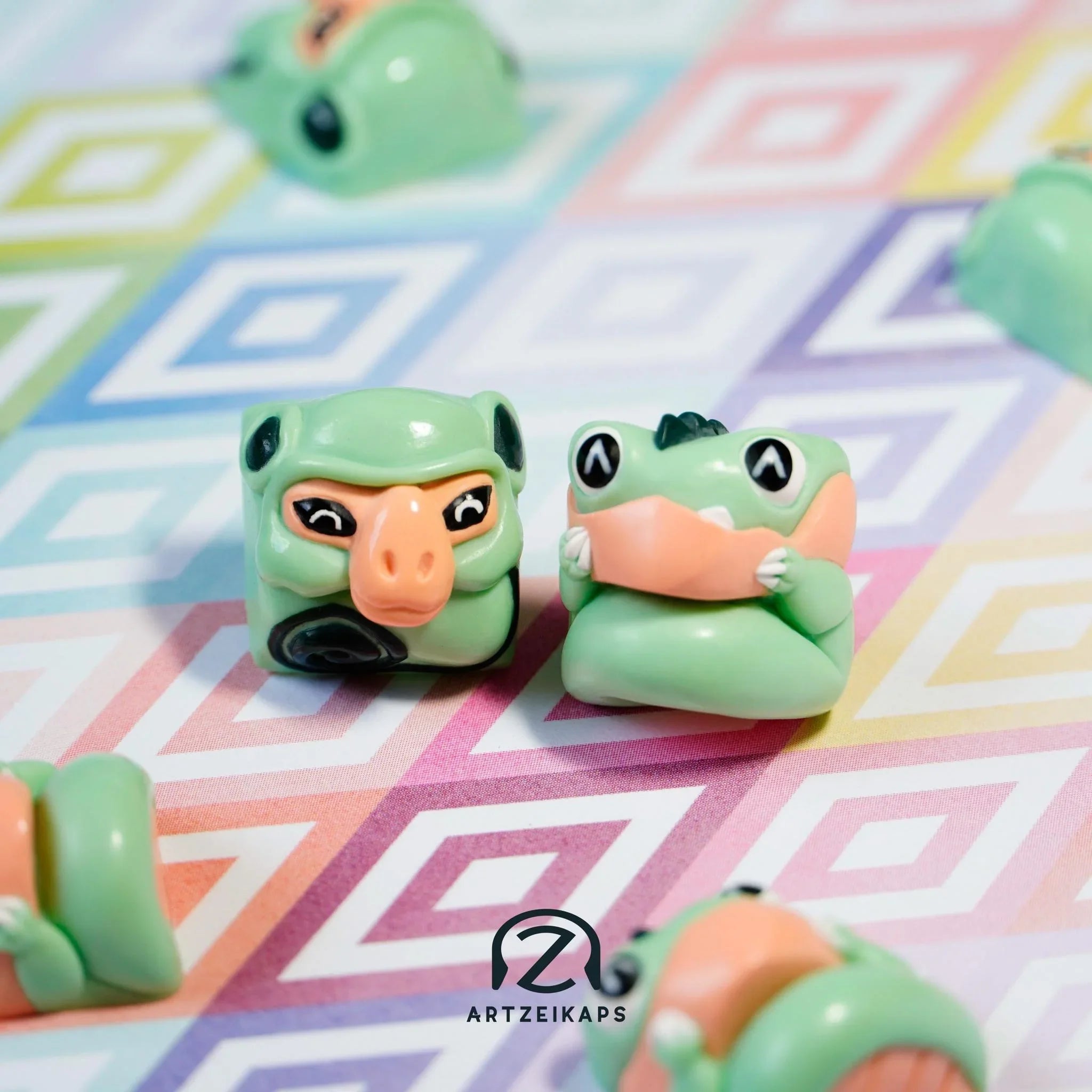 Smunkey and Chomper Minty Peach artisan keycap pair close-up on colourful geometric background