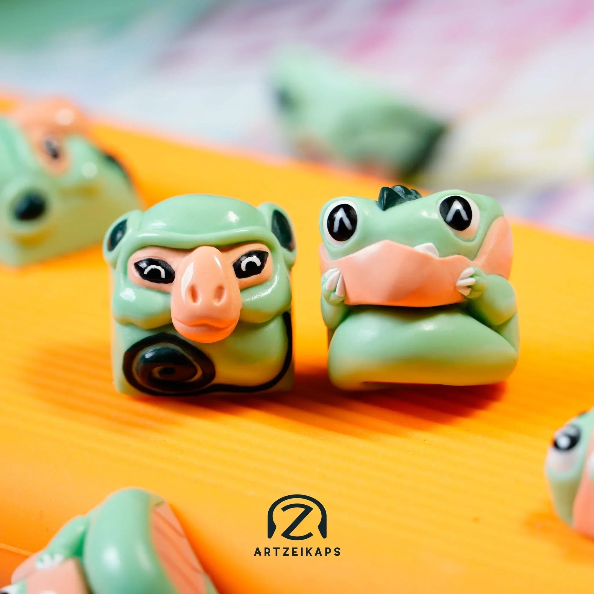 Smunkey and Chomper Minty Peach artisan keycap duo side view on orange background