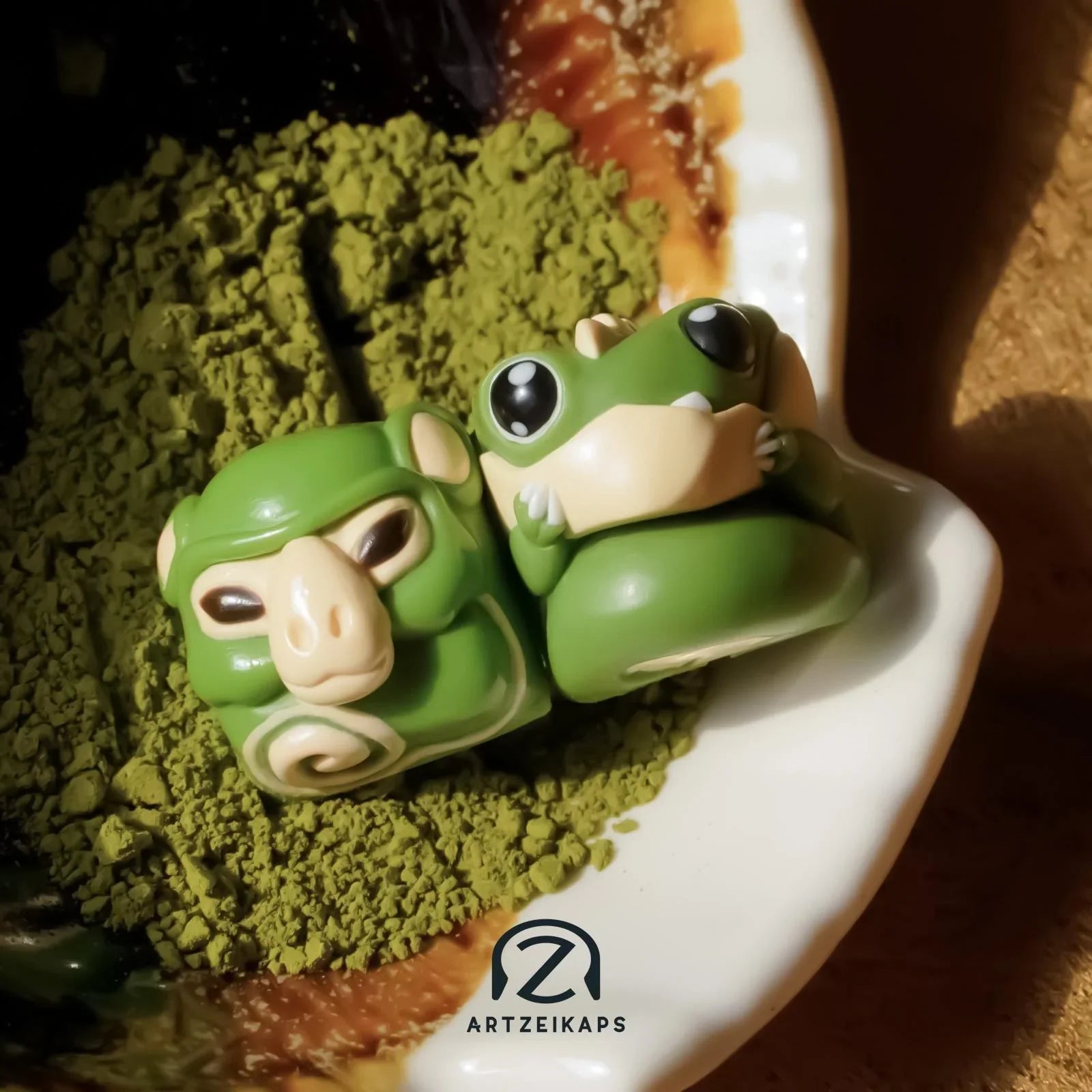 Chomper and Smunkey GMK Cream Matcha artisan keycap close-up front view on ceramic plate with matcha powder
